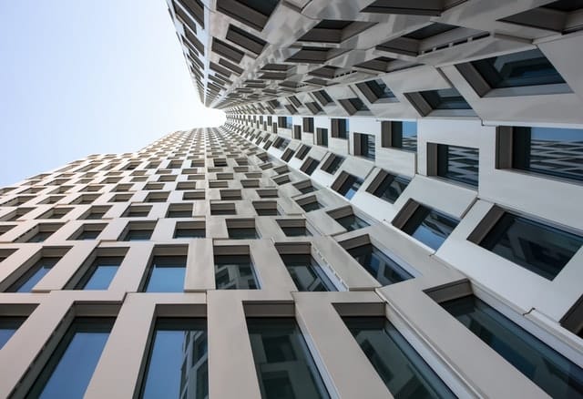 Forschperspektive entlang moderner Gebäudefassade gen Himmel