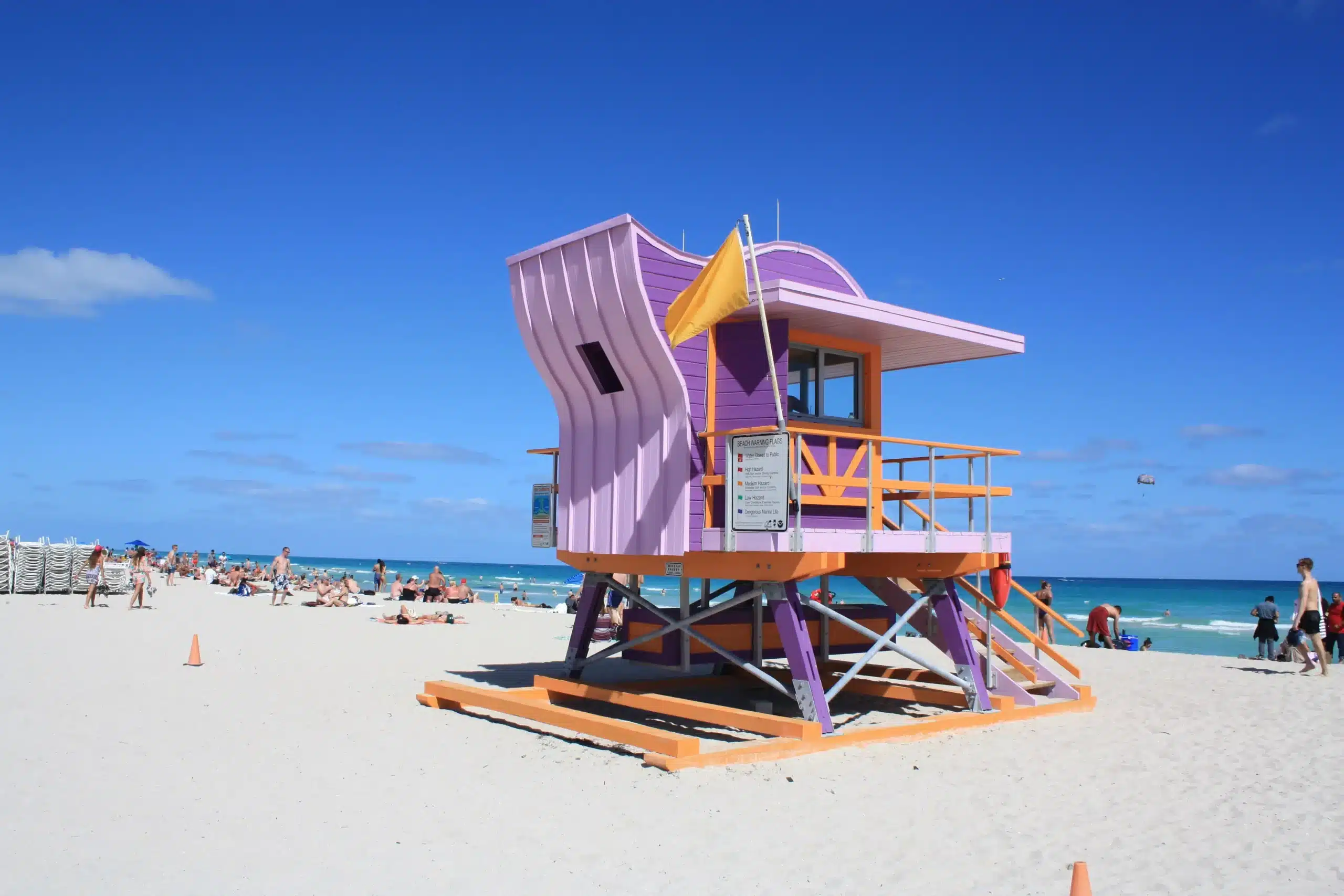 Ein hölzernes Strandwächterhäuschen in Flieder, Lila und Orange auf einem Strand, im Hintergrund das Meer. Miami Beach, Lifeguard Tower, William Lane, Foto: Archiv Architekten
