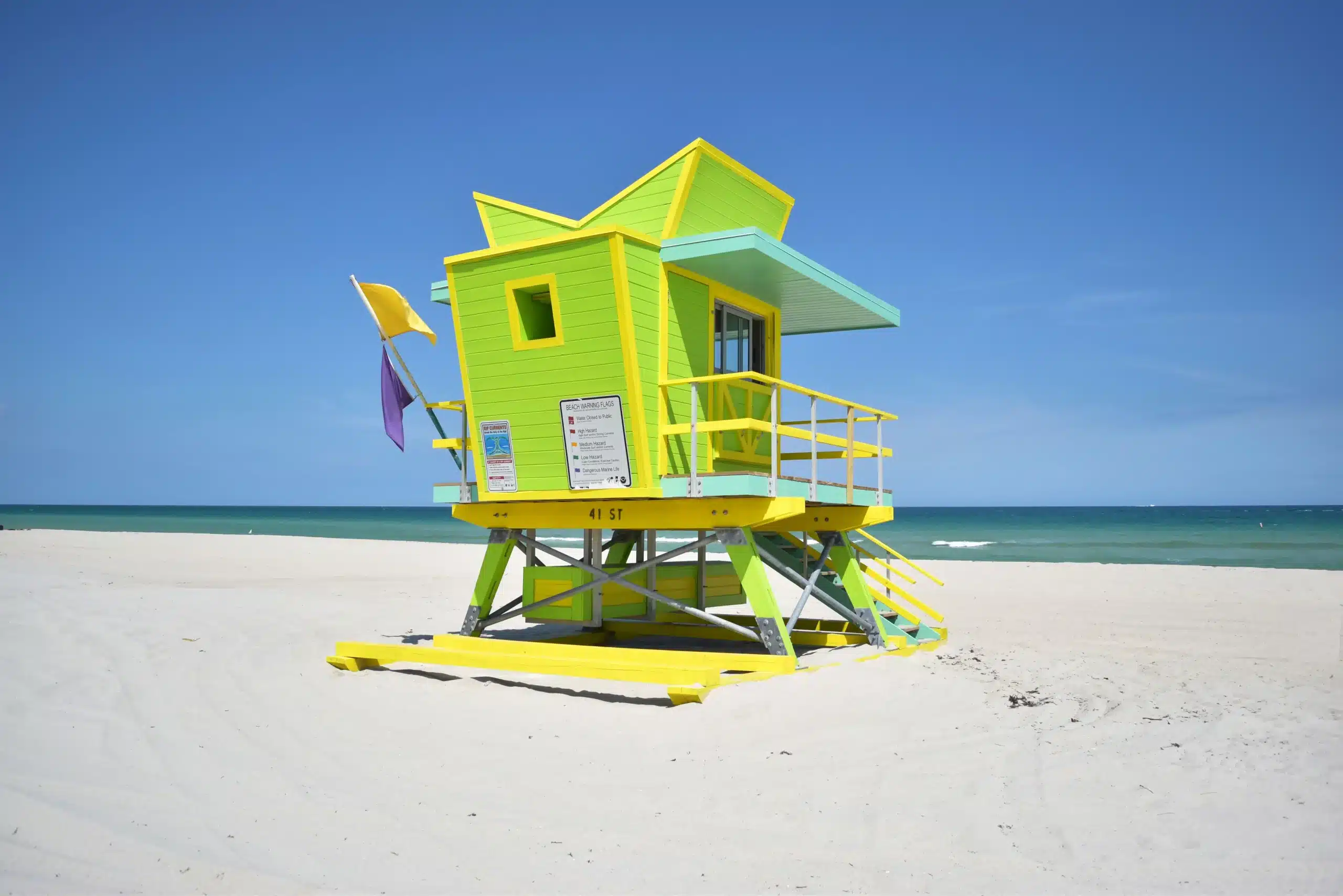 Blick von hinten auf ein hölzernes Wachhäuschen am Strand in Gründ und Gelb. Miami Beach, Lifeguard Tower, William Lane, Foto: Archiv Architekten