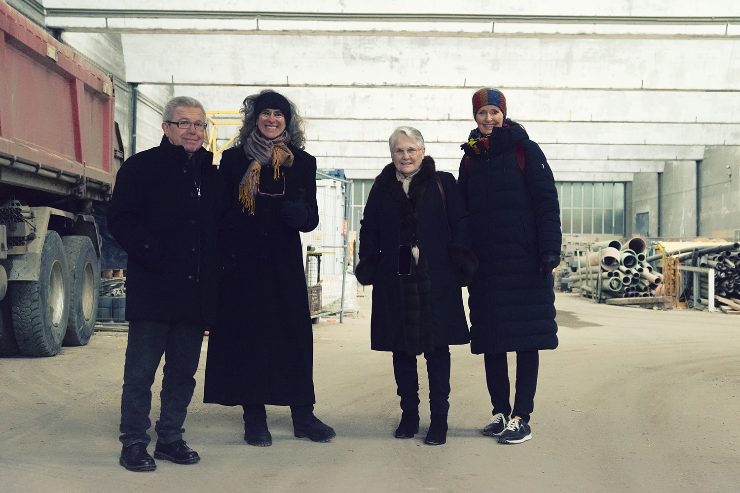 Ein Mann und drei Frauen stehen in einer Halle. Daniel Libeskind, Nancy Hecker-Denschlag, Nina Libeskind und Ditte Endriß in der alten Paketposthalle in Ulm. Foto: Petra Böger