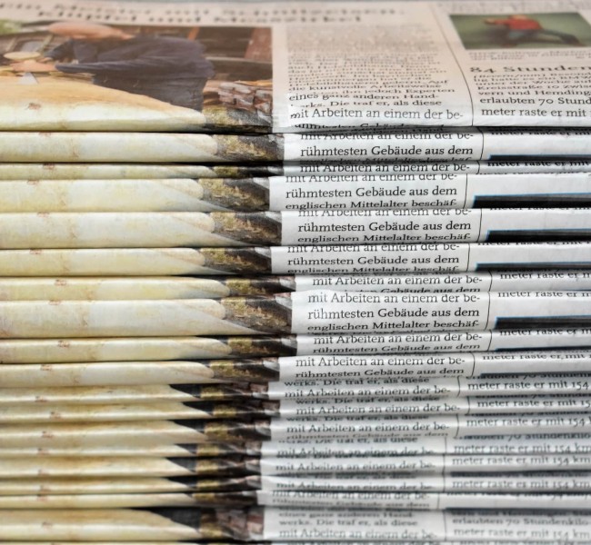 Zwei hohe Stapel Zeitungen mit unterschiedlich farbigem Papier, Foto: Waldemar via Unsplash